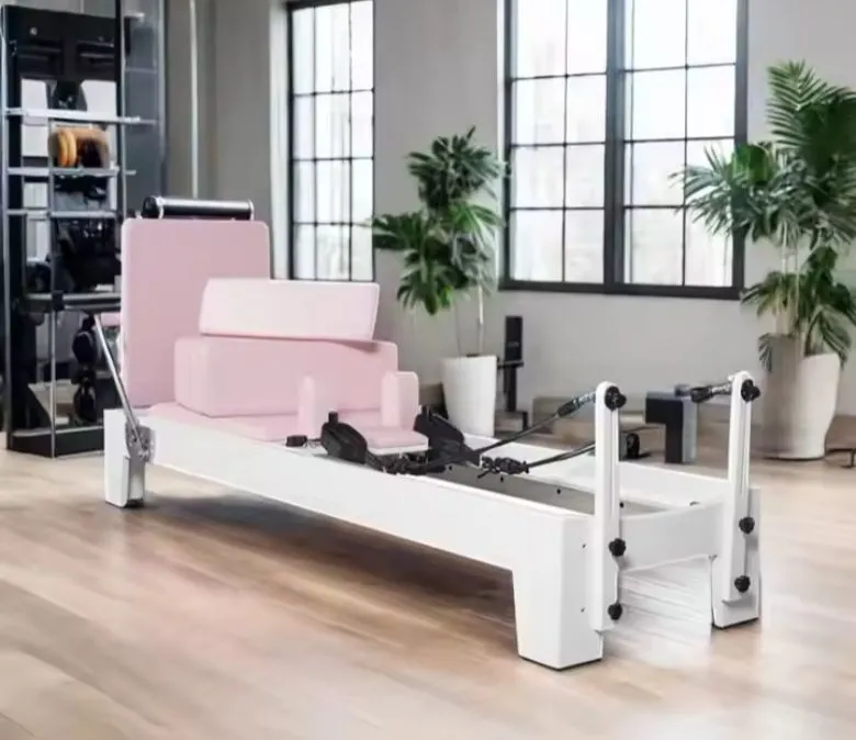 Sprzęt do pilatesu w kolorze białym, dębowym, różowym