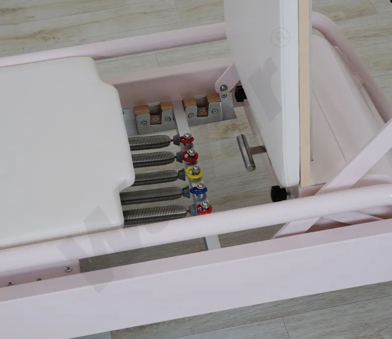 Nowy, różowy, stalowy reformator do pilatesu z wbudowanym drążkiem na stopy